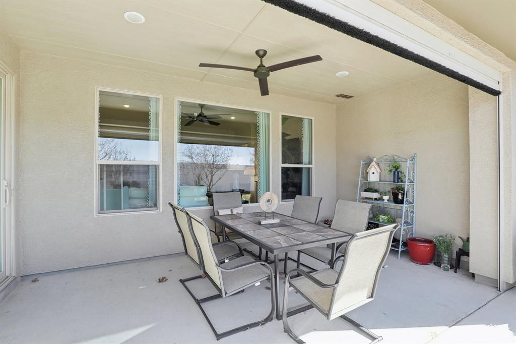 9716 Silver Rock Way Denton, TX 76207 - Photo 21 of 25 a view of a dining room and livingroom with furniture wooden floor and a rug