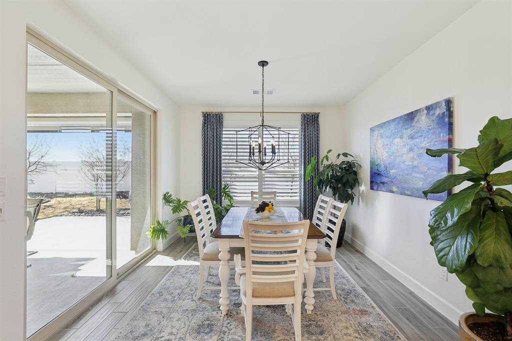 9716 Silver Rock Way Denton, TX 76207 - Photo 9 of 25 a dining room with furniture potted plants and wooden floor