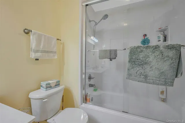 a bathroom with a granite countertop sink a toilet and shower