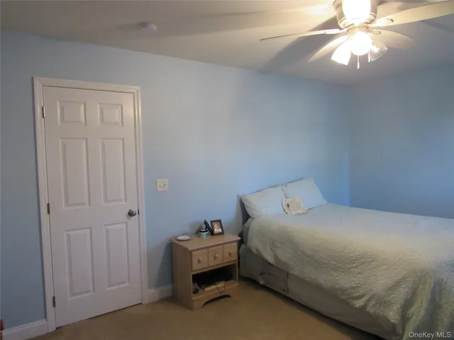 a bedroom with a bed and a chandelier fan