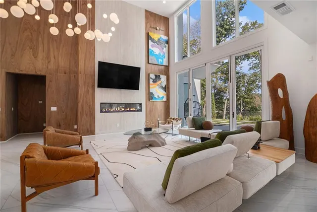 a large bedroom with furniture a flat screen tv and a large window