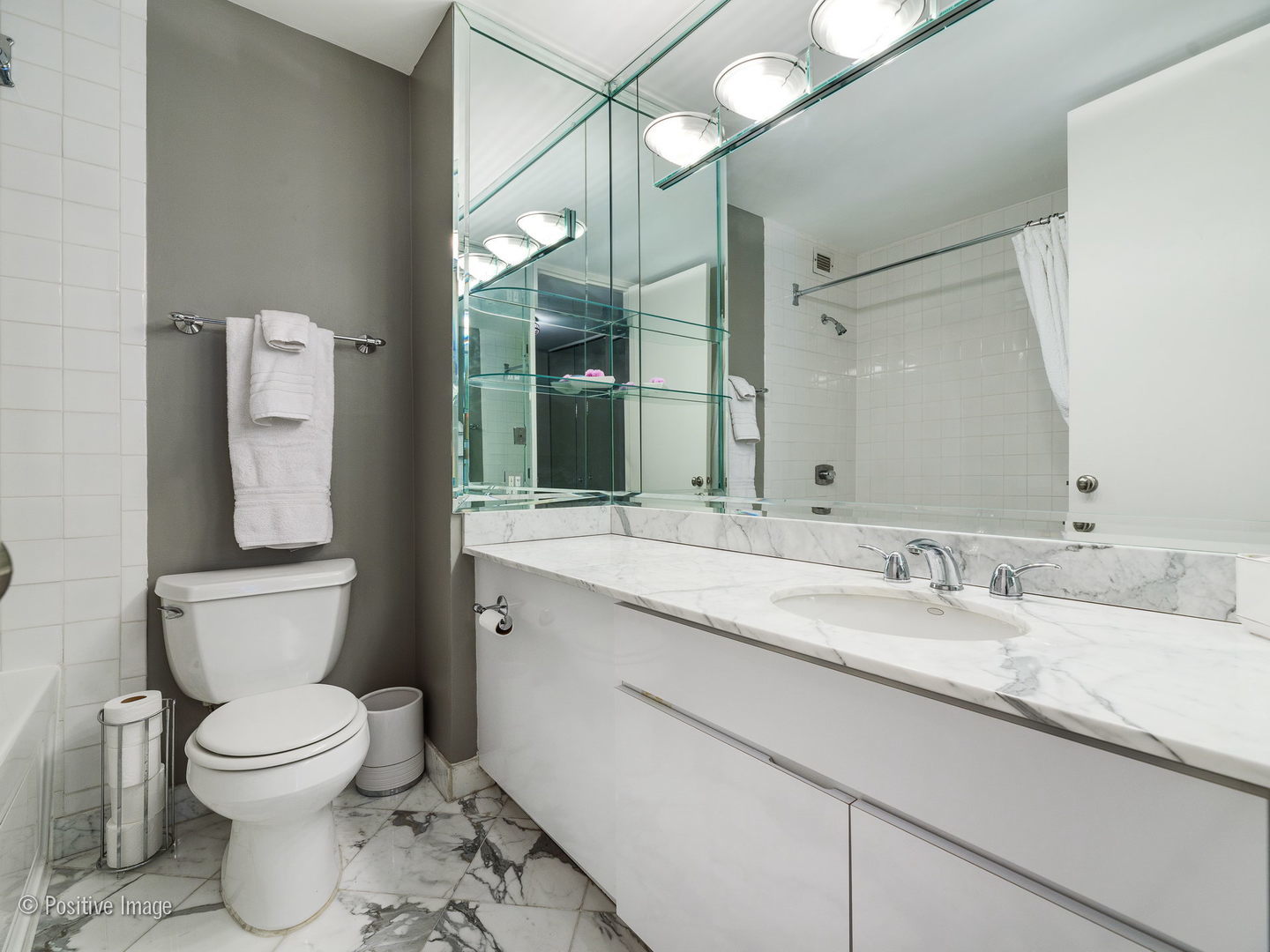 1030 North State Street, Unit 13E Chicago, IL 60610 - Photo 13 of 26 a bathroom with a granite countertop toilet sink and mirror