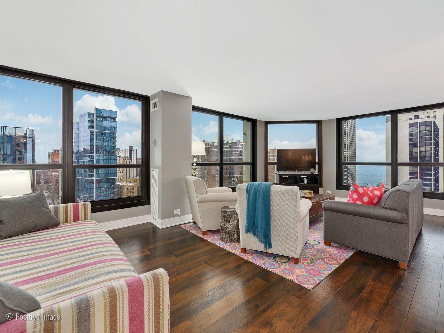 1030 North State Street, Unit 13E Chicago, IL 60610 - Photo 6 of 26 a living room with furniture a flat screen tv and a floor to ceiling window