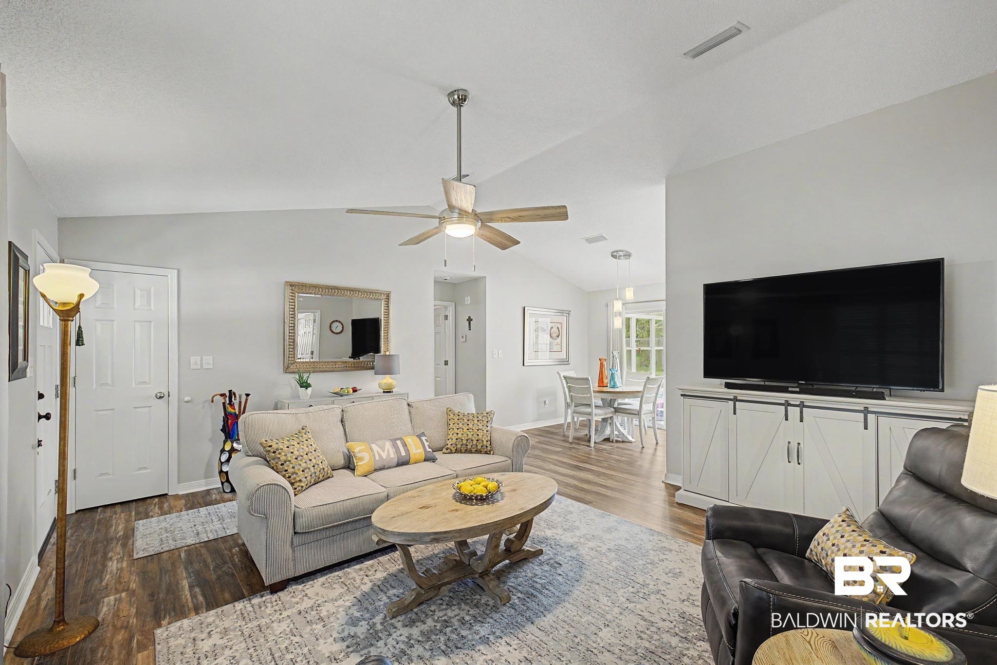 2808 Pine Ridge Drive Lillian, AL 36549 - Photo 9 of 47 Living area featuring vaulted ceilings, wood-finish flooring, and a ceiling fan with integrated lighting