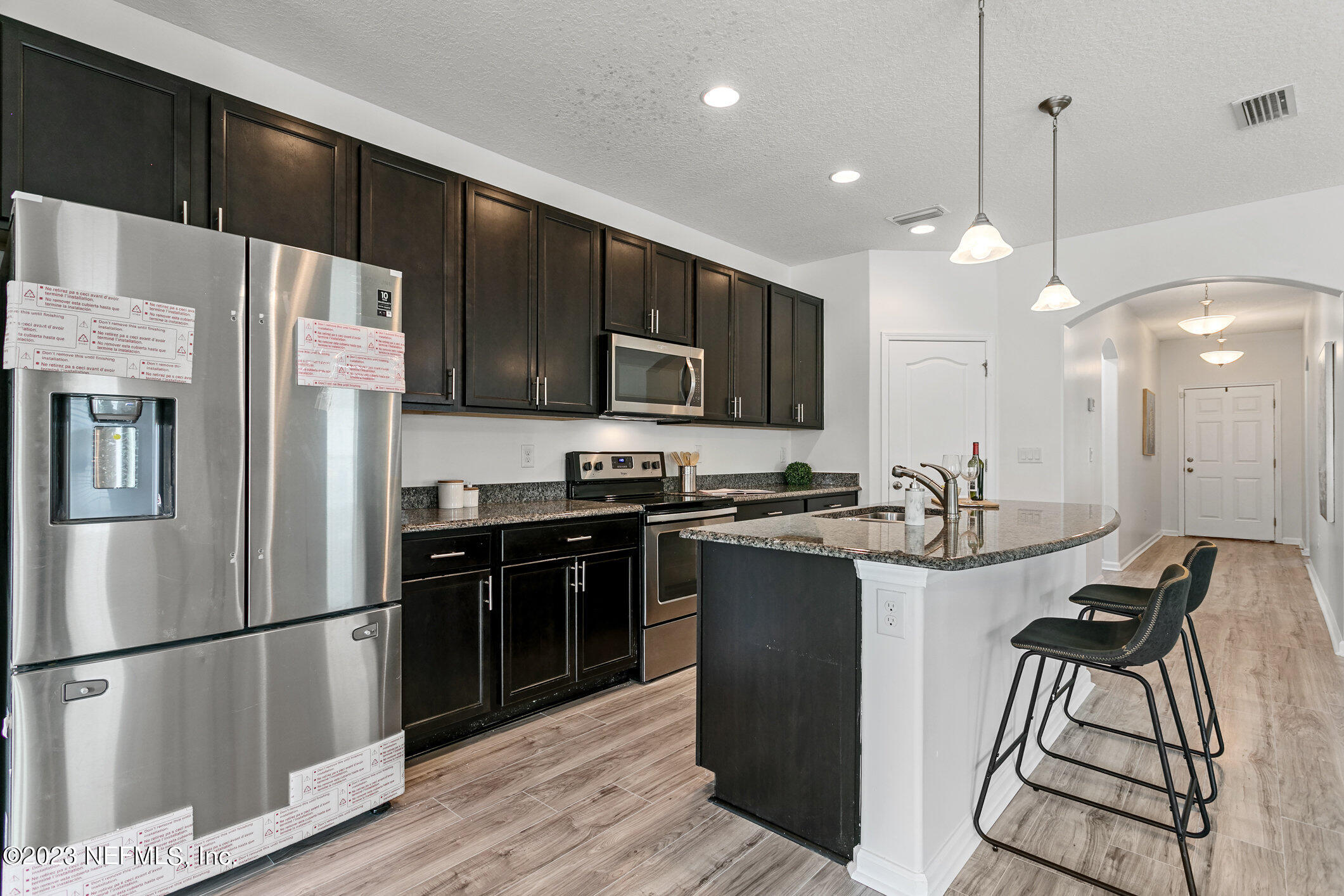 9864 Sailor Drive Jacksonville, FL 32221 - Photo 14 of 44 a kitchen with stainless steel appliances a refrigerator a stove a sink cabinets and a dining table