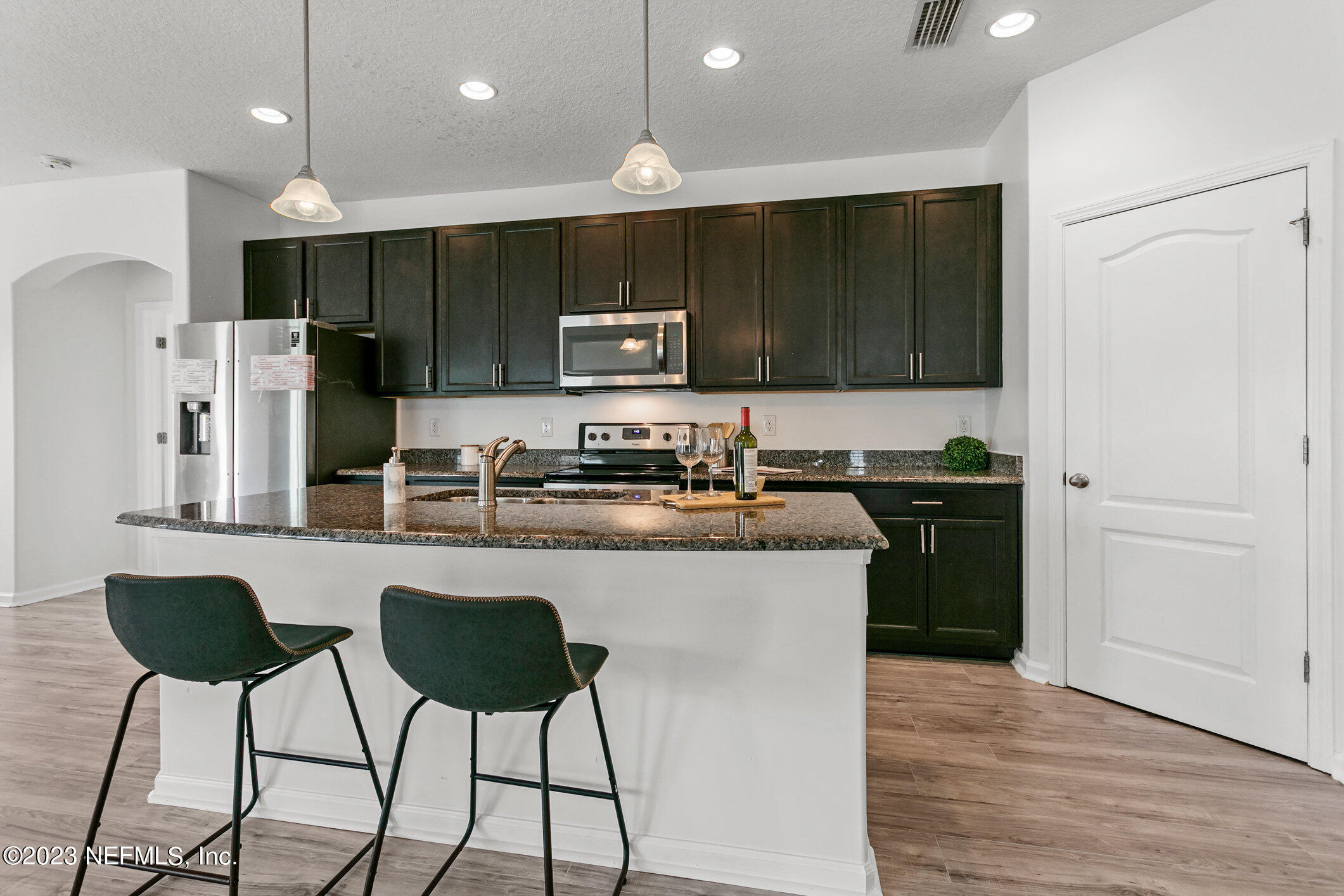 9864 Sailor Drive Jacksonville, FL 32221 - Photo 15 of 44 a kitchen with stainless steel appliances kitchen island granite countertop a refrigerator and a stove top oven