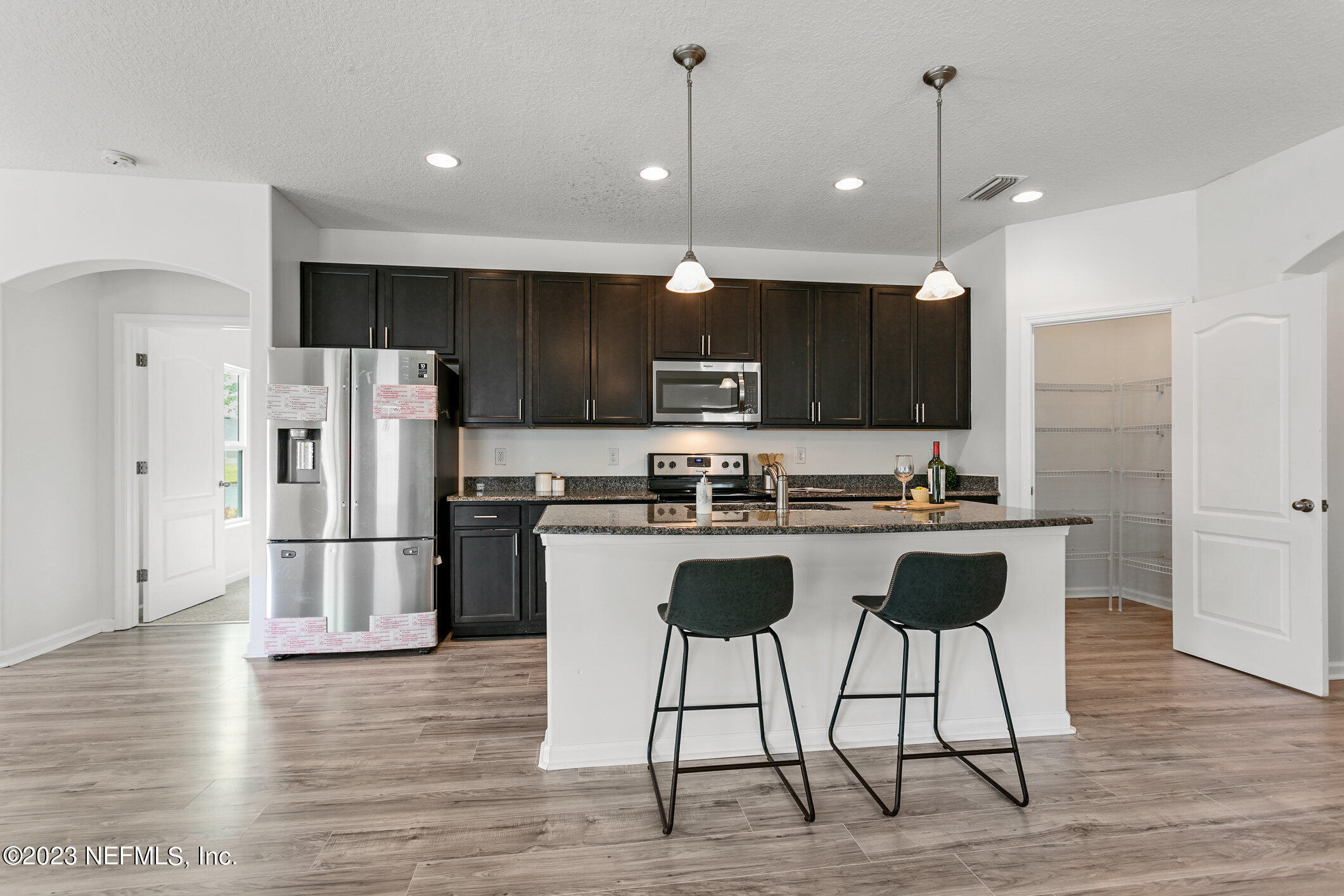 9864 Sailor Drive Jacksonville, FL 32221 - Photo 16 of 44 a kitchen with stainless steel appliances granite countertop a refrigerator a stove a sink and a oven with wooden floor