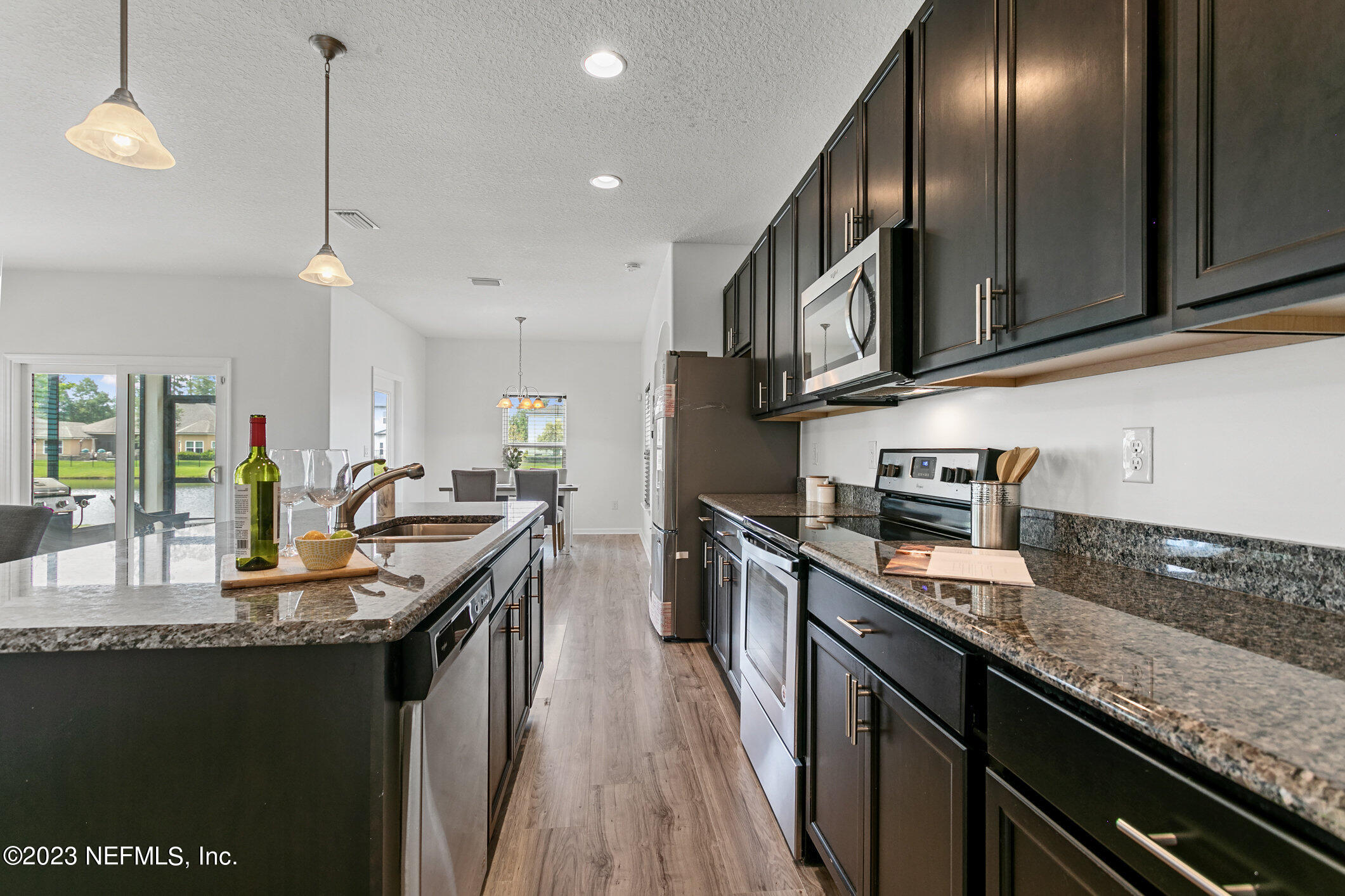 9864 Sailor Drive Jacksonville, FL 32221 - Photo 18 of 44 a kitchen with granite countertop stainless steel appliances and wooden cabinets