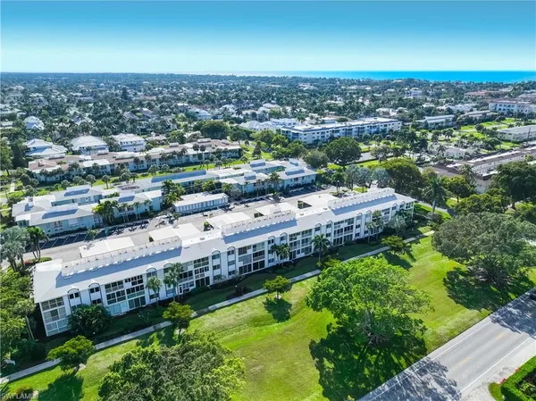 an aerial view of a residential houses with yard and lake view