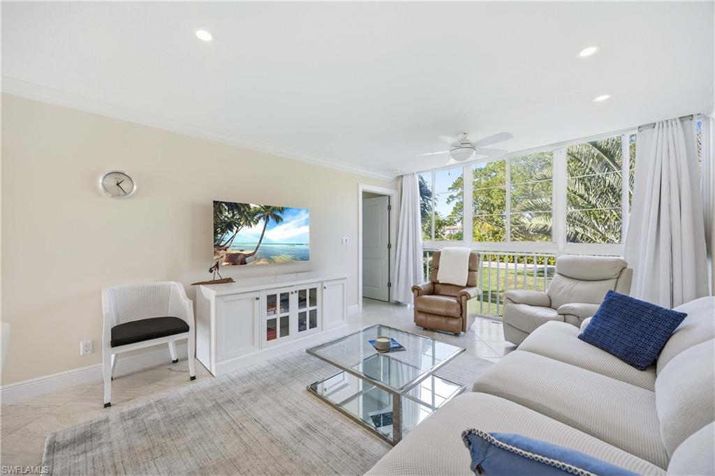 610 Broad Avenue South, Unit J610 Naples, FL 34102 - Photo 5 of 20 Living area featuring expansive windows, ornamental molding, a ceiling fan, and recessed lighting