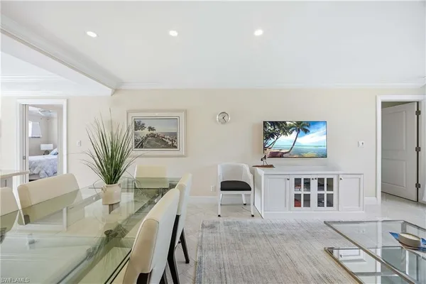 a living room with furniture a flat screen tv and a table