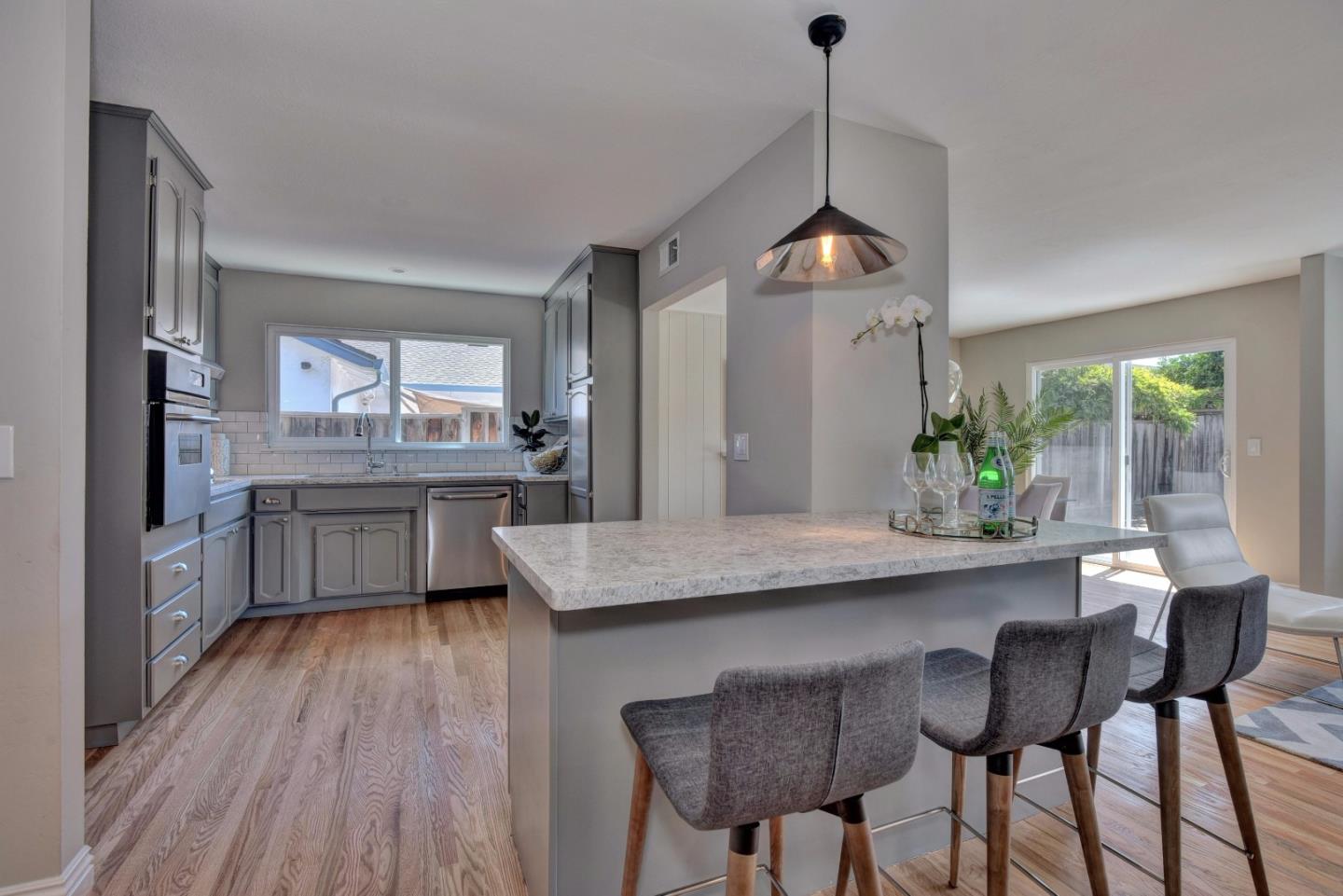 4528 Piper Drive San Jose, CA 95129 - Photo 7 of 15 a kitchen with granite countertop white cabinets and stainless steel appliances
