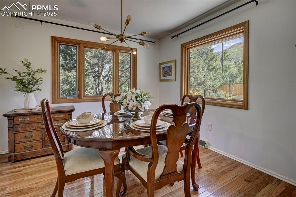 4665 Fox Road Cascade, CO 80809 - Photo 14 of 50 a dining room with furniture a chandelier and wooden floor