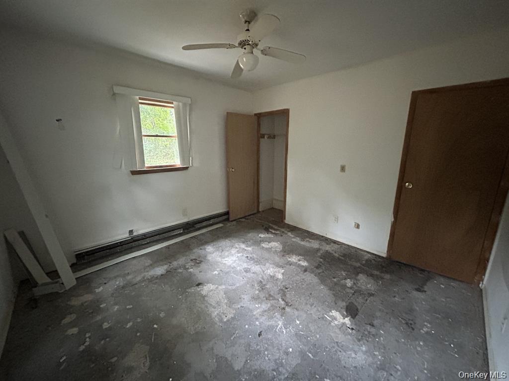 277 Prince Road Rocky Point, NY 11778 - Photo 15 of 19 Unfurnished bedroom featuring a closet, ceiling fan, and a baseboard radiator