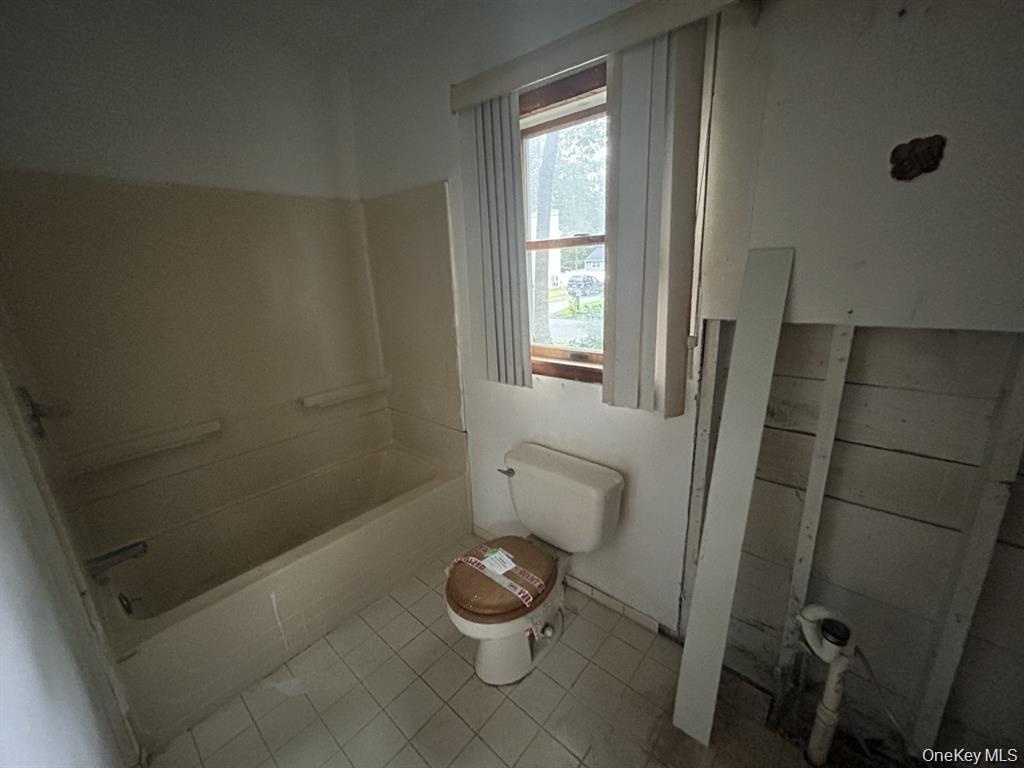 277 Prince Road Rocky Point, NY 11778 - Photo 16 of 19 Full bath featuring toilet and light tile patterned flooring