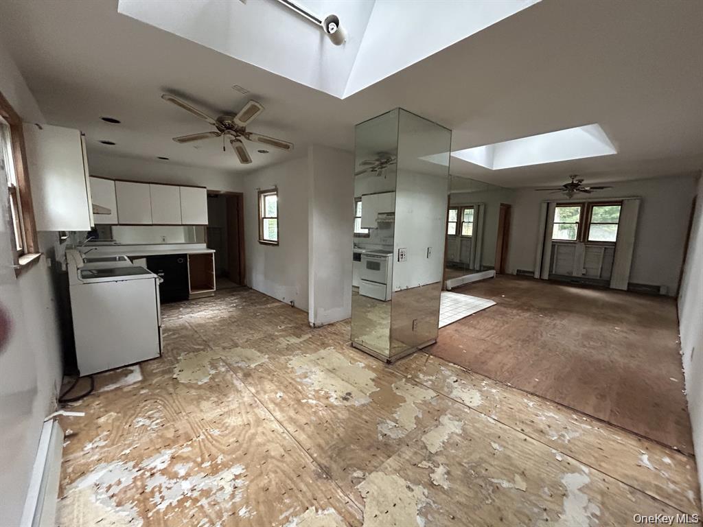 277 Prince Road Rocky Point, NY 11778 - Photo 7 of 19 Kitchen featuring white cabinetry, a ceiling fan, a skylight, light countertops, and white stove