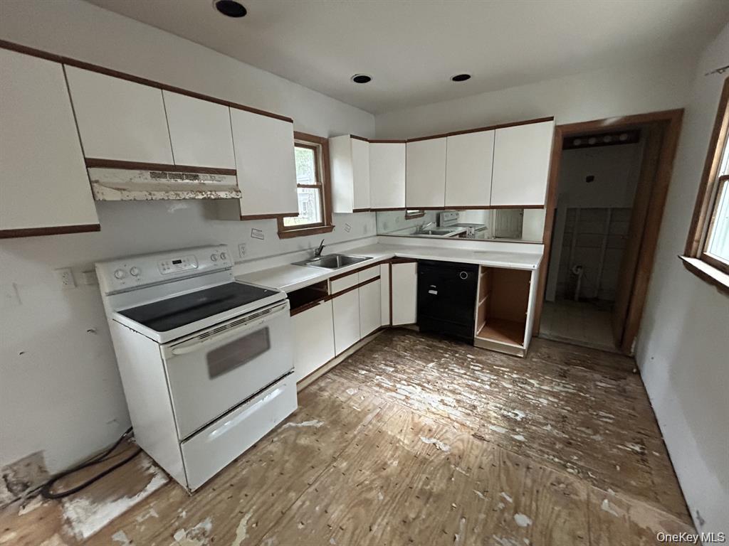 277 Prince Road Rocky Point, NY 11778 - Photo 8 of 19 Kitchen featuring white cabinetry, electric range, light countertops, and under cabinet range hood