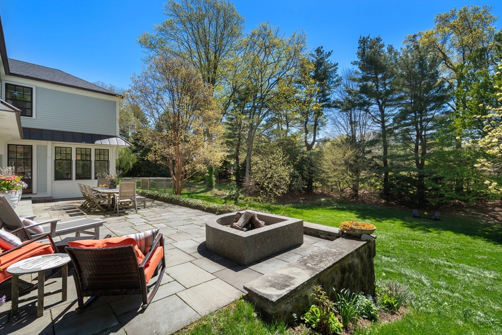 21 Sargent Crossway Brookline, MA 02445 - Photo 11 of 36 a view of a backyard with table and chairs and a fire pit