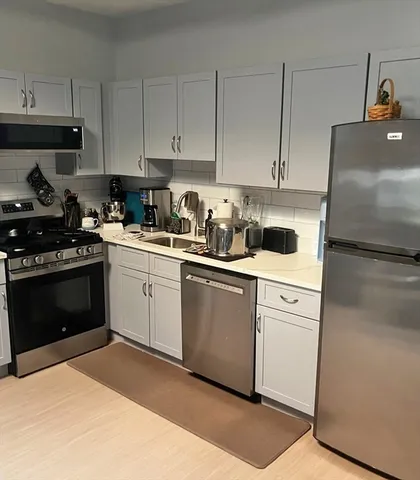 a kitchen with granite countertop wooden cabinets and a stove top oven