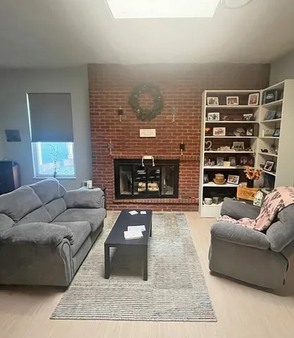 a view of empty room with wooden floor and fireplace