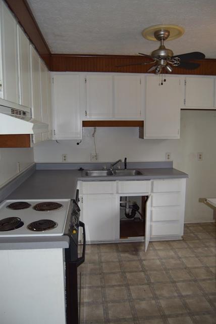 1608 Macon Road Perry, GA 31069 - Photo 4 of 11 a kitchen with granite countertop a stove and a white cabinets