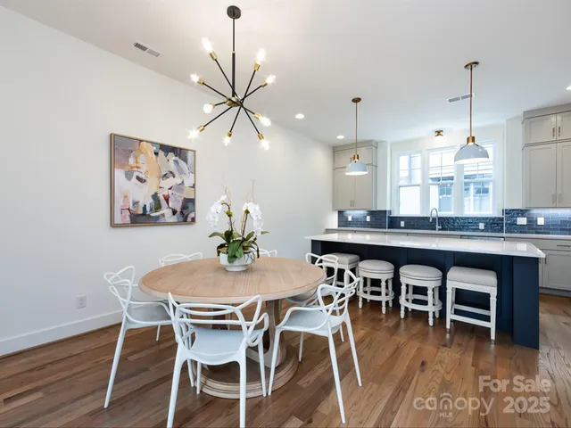 a dining room with wooden floor a chandelier a wooden table and chairs