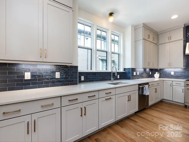 a kitchen with stainless steel appliances granite countertop a sink a stove and cabinets