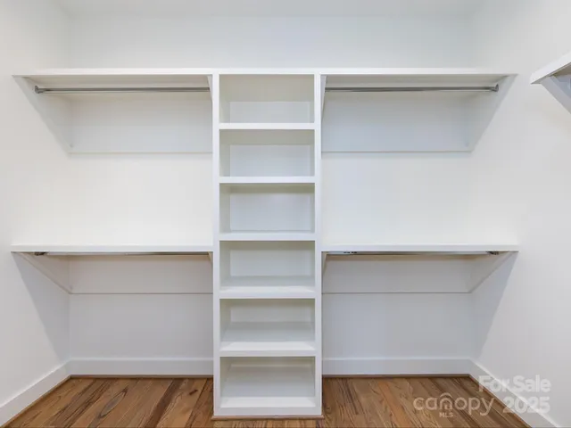a view of walk in closet with empty racks