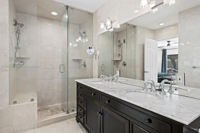 a bathroom with a granite countertop sink a shower and a mirror