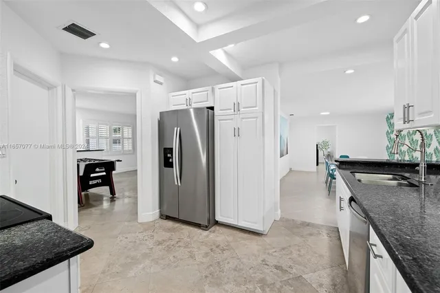 a kitchen with refrigerator and chairs