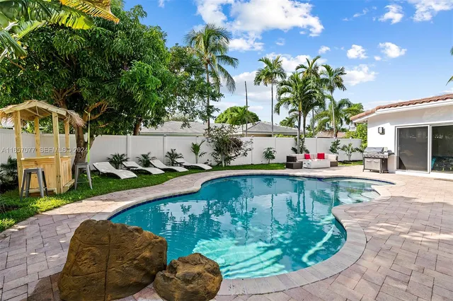 a front view of a house with a garden and swimming pool