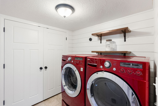 2485 South 1100th Street West Logan, UT 84321 - Photo 30 of 53 Laundry area featuring shiplap wall paneling, two-panel bifold doors, and wood-finish shelving with black metal brackets