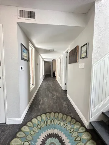 a view of a hallway to a bedroom with wooden floor and entryway