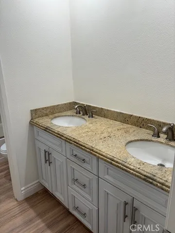 a bathroom with a granite countertop sink and white cabinets