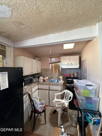 a kitchen with a dining table chairs and a refrigerator