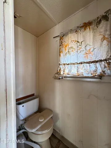 a bathroom with a toilet and a shower curtain