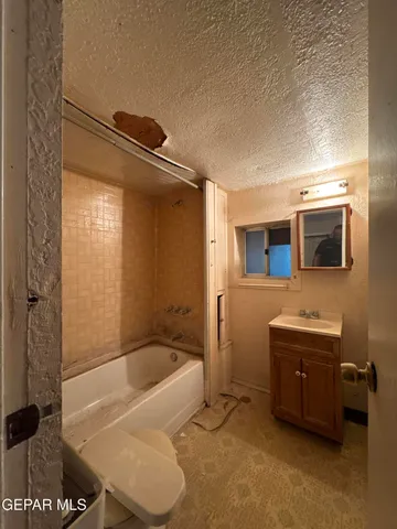 a bathroom with a tub a sink and a mirror