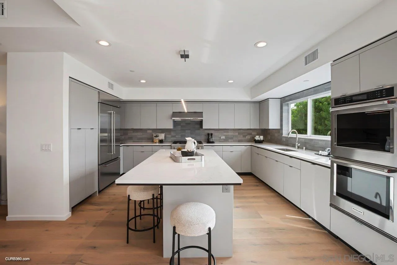8352 La Jolla Shores Drive La Jolla, CA 92037 - Photo 12 of 33 a large kitchen with kitchen island a dining table chairs stainless steel appliances and cabinets