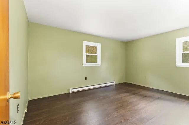 a view of a room with wooden floor and a window