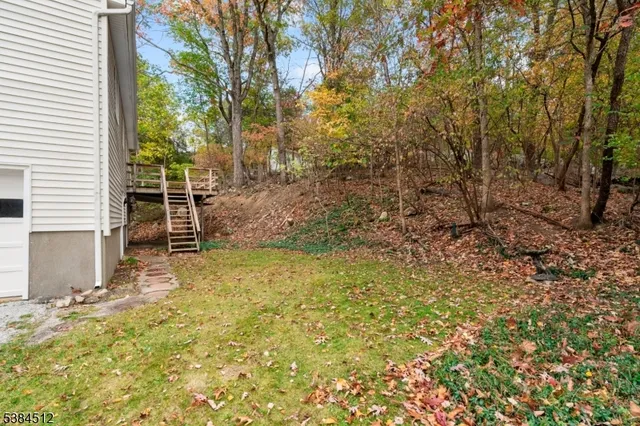 a view of a backyard with large tree and wooden fence