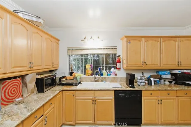 a kitchen with stainless steel appliances granite countertop a stove a sink and dishwasher a refrigerator with wooden cabinets