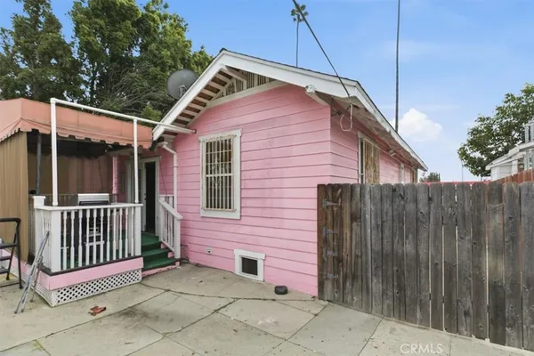 a view of a small house and wooden fence