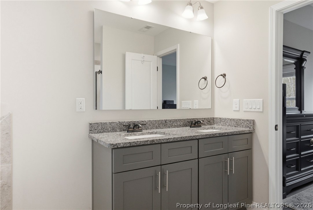 240 Meherrin Loop Raeford, NC 28376 - Photo 30 of 50 a bathroom with a granite countertop sink and a mirror