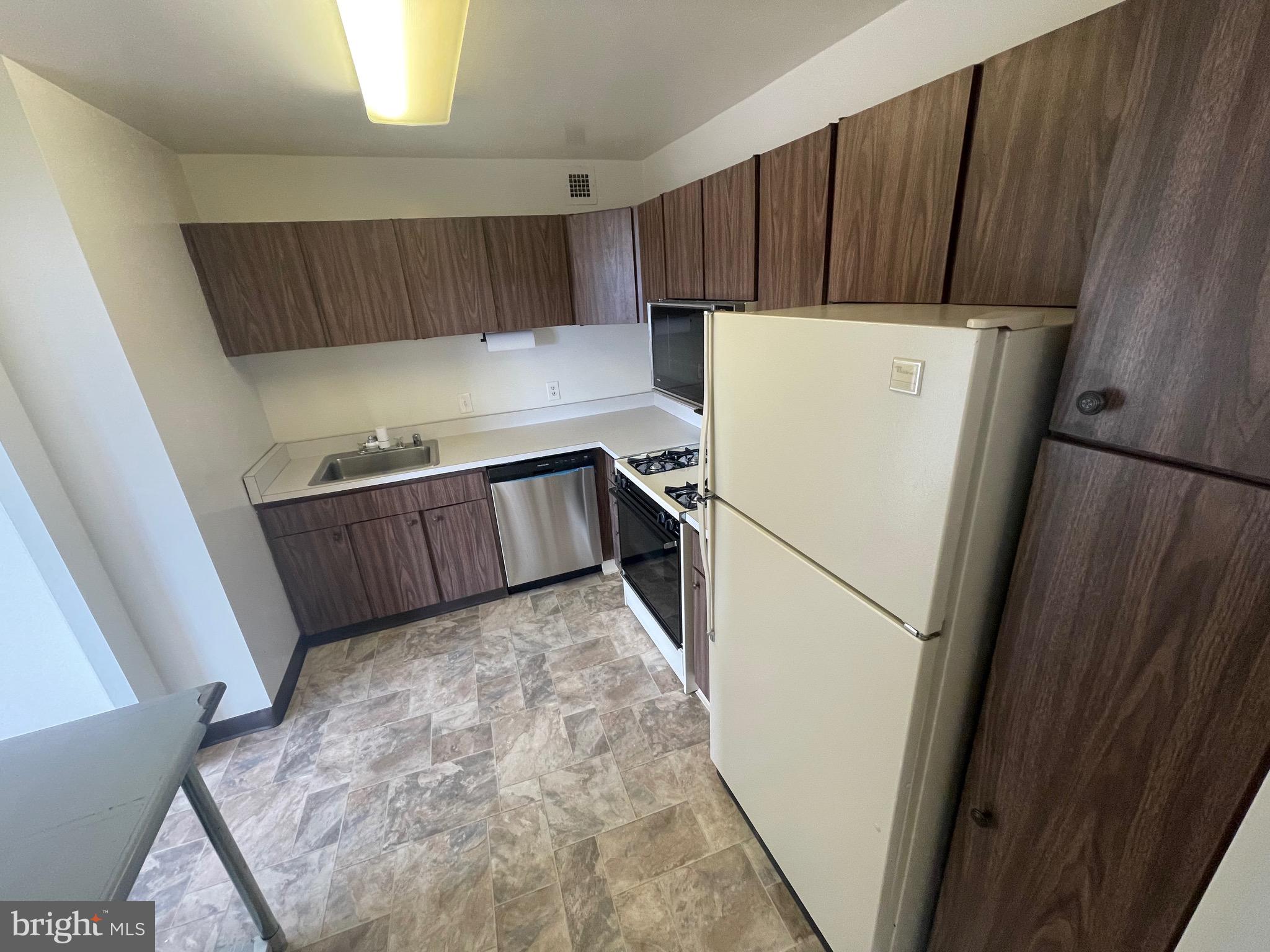 1111 University Boulevard West, Unit 1214A Silver Spring, MD 20902 - Photo 9 of 24 a kitchen with sink cabinets and refrigerator