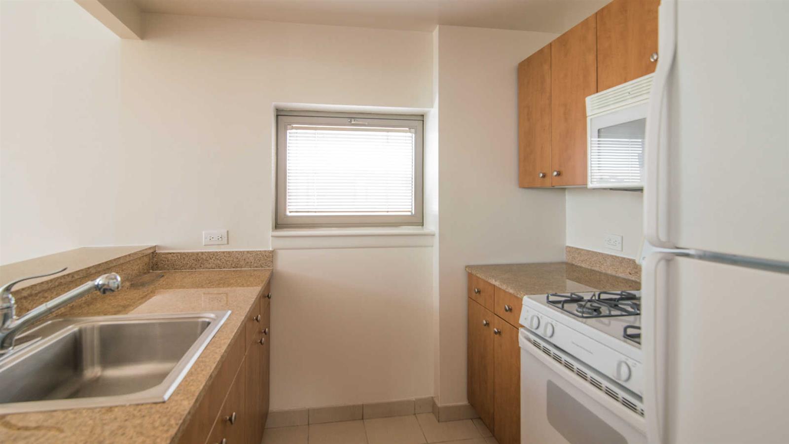 400 West 37th Street, Unit 15F Manhattan, NY 10018 - Photo 8 of 10 a utility room with a sink a stove and a window