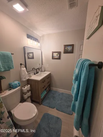 a view of a house with a yard and a large tree