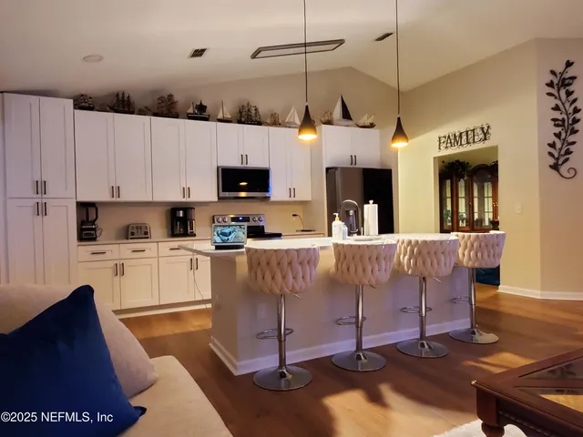 a kitchen with kitchen island granite countertop a sink a counter top space appliances and cabinets