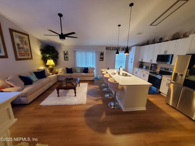 a living room with furniture a chandelier and a dining table
