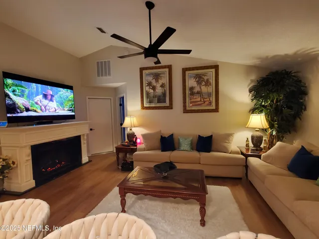 a living room with furniture a flat screen tv and a fireplace
