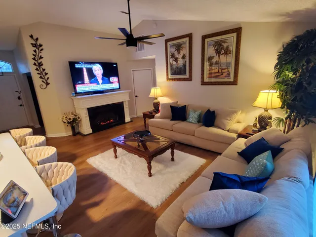 a living room with furniture a flat screen tv and a fireplace